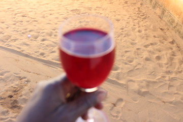 glass of red wine on the beach
