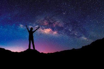 Happy freedom woman on the mountain  with starry night sky milkyway. freedom and victory concept.