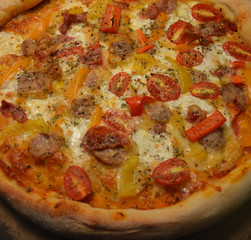 Fresh Home Made Italian Style Pizza Topped with Tomato, Sausage, Mozzarella, and Vegetables