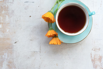 Cup of hot tea on a white wooden table background.