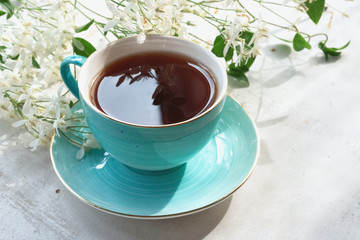 Cup of hot tea on a white wooden table background.