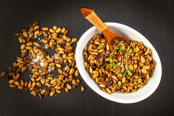 Roasted and salted sunflower seeds. Sunflower seeds in the bowl over the wooden background. Vegan food.