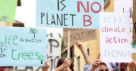 Public demonstration on the street against global warming and pollution. Group of multiethnic people making protest about climate change and plastic problems in the oceans