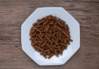 plate of fusili pasta in a wooden background
