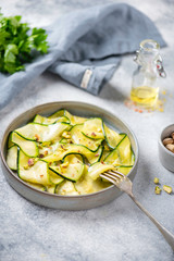 Carpaccio of zucchini with pistachio on grey background on linen napkin