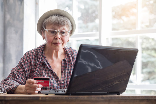 Elderly Woman With Computer And Credit Card Inside.