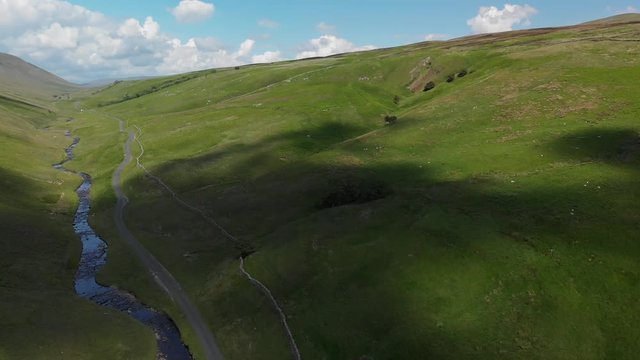 A descending shot of the Barbon Beck Valley, Carnforth, Lancashire. This footage shows the shadows of the clouds travelling across the stunning and undulating landscape.