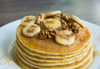 Pancakes with bananas, honey and walnuts on a plate