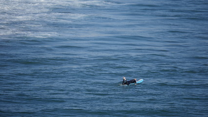 Beach with waves crashing at the ocean with surfer shot in high resolution 