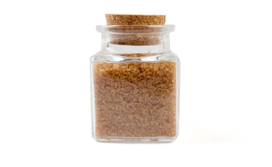 Brown or cane sugar in glass  jar on isolated on white background. front view. spices and food ingredients.