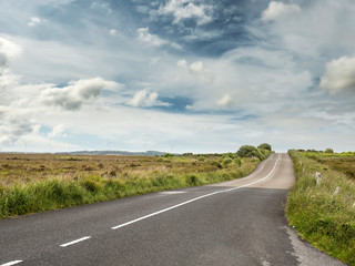 Asphalt road with new and old surface, Blue colorful sky. green fields.