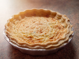 Quiche lorraine close up. French style pastry food. Sun flare.
