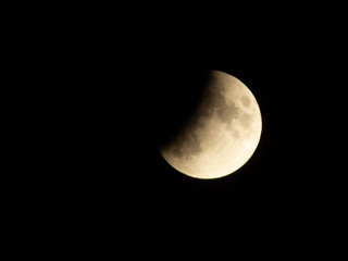 Progressing partial lunar eclipse with visible lunar seas and craters on moon surface - obrazy, fototapety, plakaty