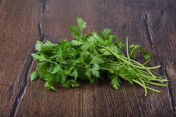 Fresh parsley leaves on wooden table. Rustic style.
