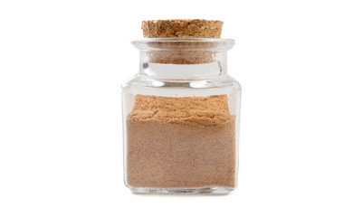 milled or ground nutmeg in glass  jar on isolated on white background. front view. spices and food ingredients.