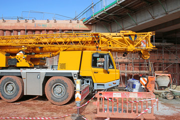 Mobile crane by a bridge under construction