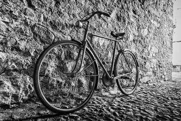 Fototapeta na wymiar Old Bicycle in an alley next to a stone wall