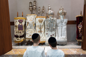 zwei religiöse Junge stehen vor dem Torahschrank und beten