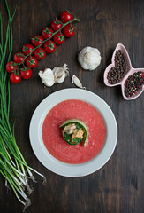 Traditional spanish cold gazpacho soup with mussels. Wooden background.