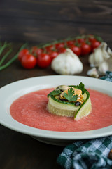Traditional spanish cold gazpacho soup with mussels. Wooden background.