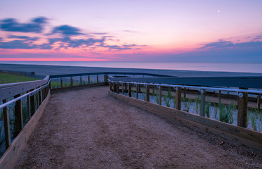 Obraz premium Beautiful sunrise over Lavallette Beach, New Jersey featuring sand on the foreground and sunny sky on the background