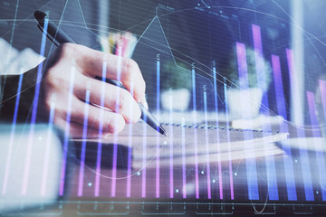 Financial forex charts displayed on woman's hand taking notes background. Concept of research. Double exposure