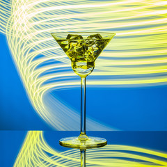 Glass with cocktail on the glass table on the neon lights background