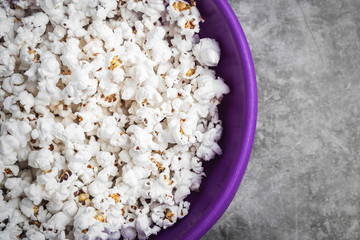 popcorn in a plate on the table, gray background, copy space, close-up