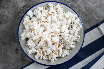 popcorn in a plate on the table, gray background, copy space, close-up