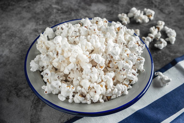 popcorn in a plate on the table, gray background, copy space, close-up