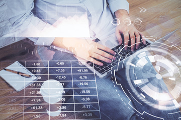 Forex graph with businessman working on computer in office on background. Concept of hardworking. Double exposure.