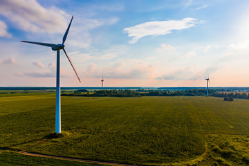 Wind turbines set up in green field, summer landscape. Energy concept