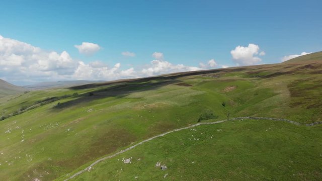 Flying backwards across Barbon Beck Valley, Carnforth, Lancashire. This shot moves gently forward across stunning and undulating green landscape.