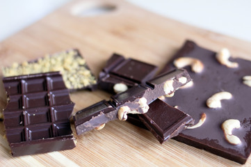 chocolate with cashew on a wooden surface, brown healthy vegan chocolate made from cocoa, sweetness for tea