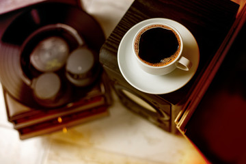 Music and coffee concept. Vinyl with speaker over a cup of coffee and headphones beside.