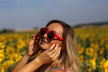 Cute girl in the field full of sunflowers