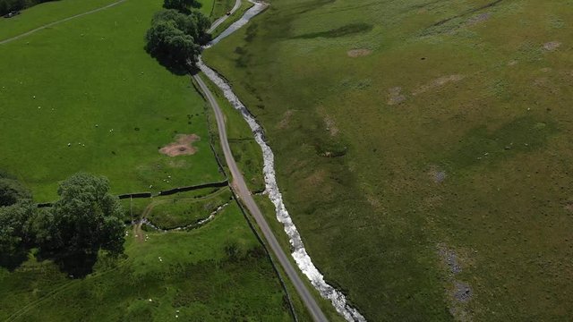 Looking down at the stream and road of the Barbon Beck Valley, Carnforth, Lancashire whilst slowly descending. Taken in June to capture the best of the nature in the area at this time of year. 