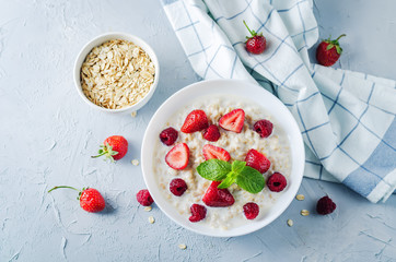 Oatmeal porridge with fresh strawberries and raspberries