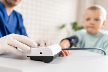 Close-up of the apparatus for measuring blood pressure. Doctor measuring blood pressure of a little boy. Diagnostic, healthcare, medical service. Doctor pediatrician concept
