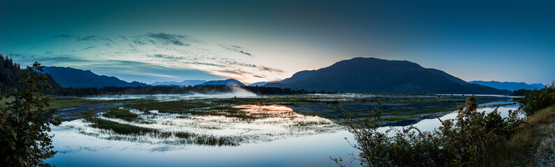 Fototapeta premium Early morning panorama of marshlands and mountain range 