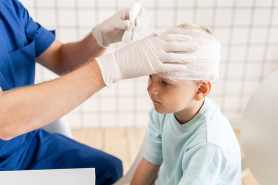 Sports Injury. Doctor Makes Bandage On Head Patient, In The Hospital.