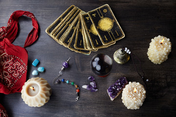 Still life with the tarot cards, magic stones and candles on wooden table. Fortune telling seance...