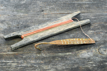 Ancient tackle for vertical flashing predatory fish. Copper forged spinner and reel with rope on...