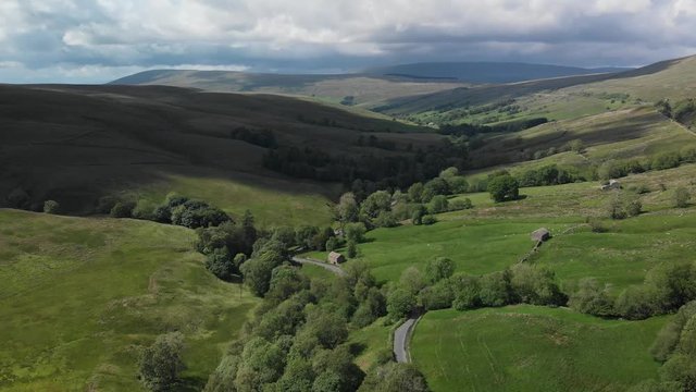An aerial static shot looking at the countryside around Dent, Cumbria. The scenery is green and sunny and was filmed in the Summer.
