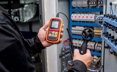 Technician use hand-held anemometer measuring air flowing measurement, wind speed and pressure.