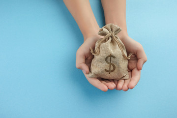 Women hold a money bag on blue background, Saving money for future investment concept.