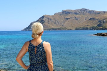 a girl looks out over the sea - cala mata Artà Mallorca Balearic Islands Spain