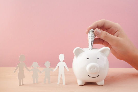 Family Saving Concept With Piggy bank And Family Paper Cut on Pink Background
