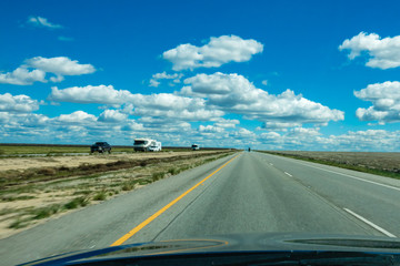 Windshield view of road trip in central California, approaching Highway 5 on a partly cloudy early spring day. 