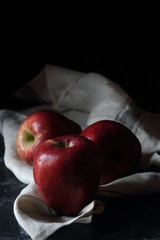 Red apples on a black background, still life apples
